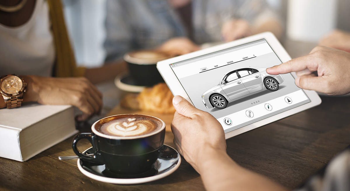 Person having a coffee and browsing cars on a tablet screen