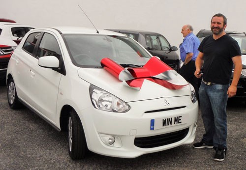 Competition winner Alex with their new white Mitsubishi
