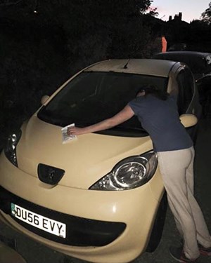 Customer hugging the bonnet of their yellow car