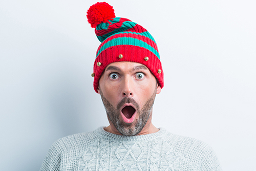 Person in festive elf hat looking shocked