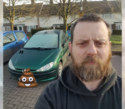 Selfie of a man with his old car and a poo emoji!