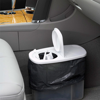 Small bin with lid in footwell of car