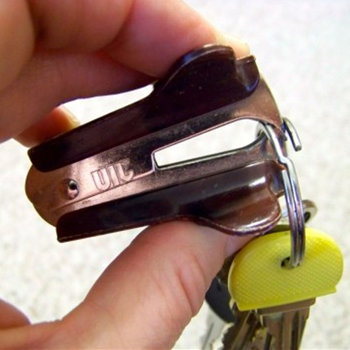 Staple remover being used to undo a keyring