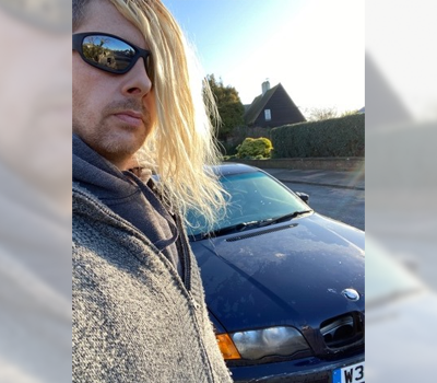 Selfie of a man in sunglasses with his car