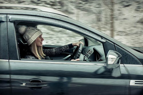 Woman in bobble hat driving in a car