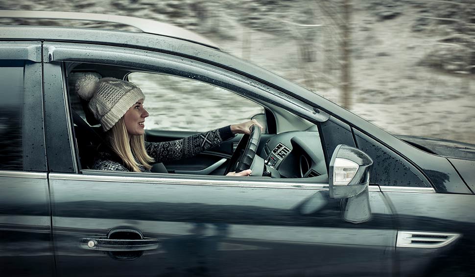 Woman in bobble hat driving in a car