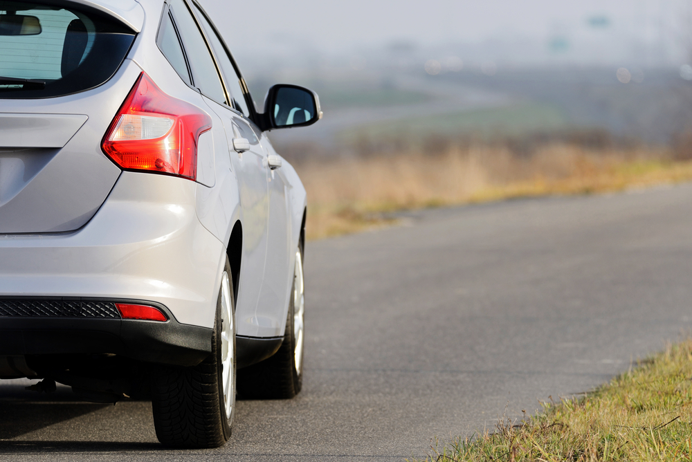 Photo of the rear of a ford focus driving on a country road