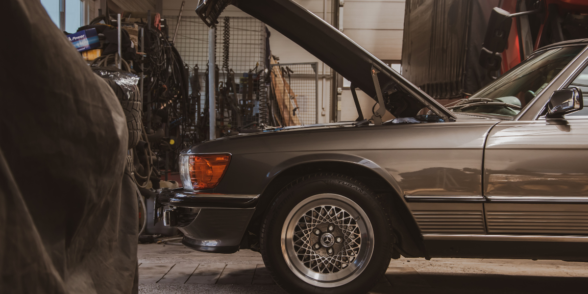 Old but immaculate Mercedes with bonnet up in a car garage